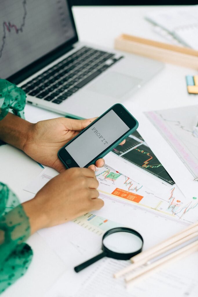 Close-up of a woman using a smartphone to analyze business data with charts and graphs.